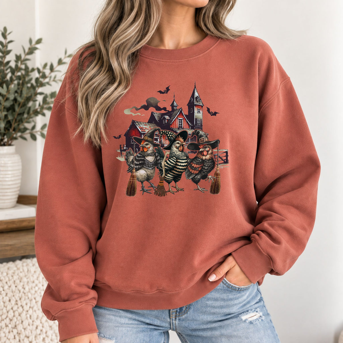 Rust-orange sweatshirt with witchy chicken and haunted house graphic, crew neck