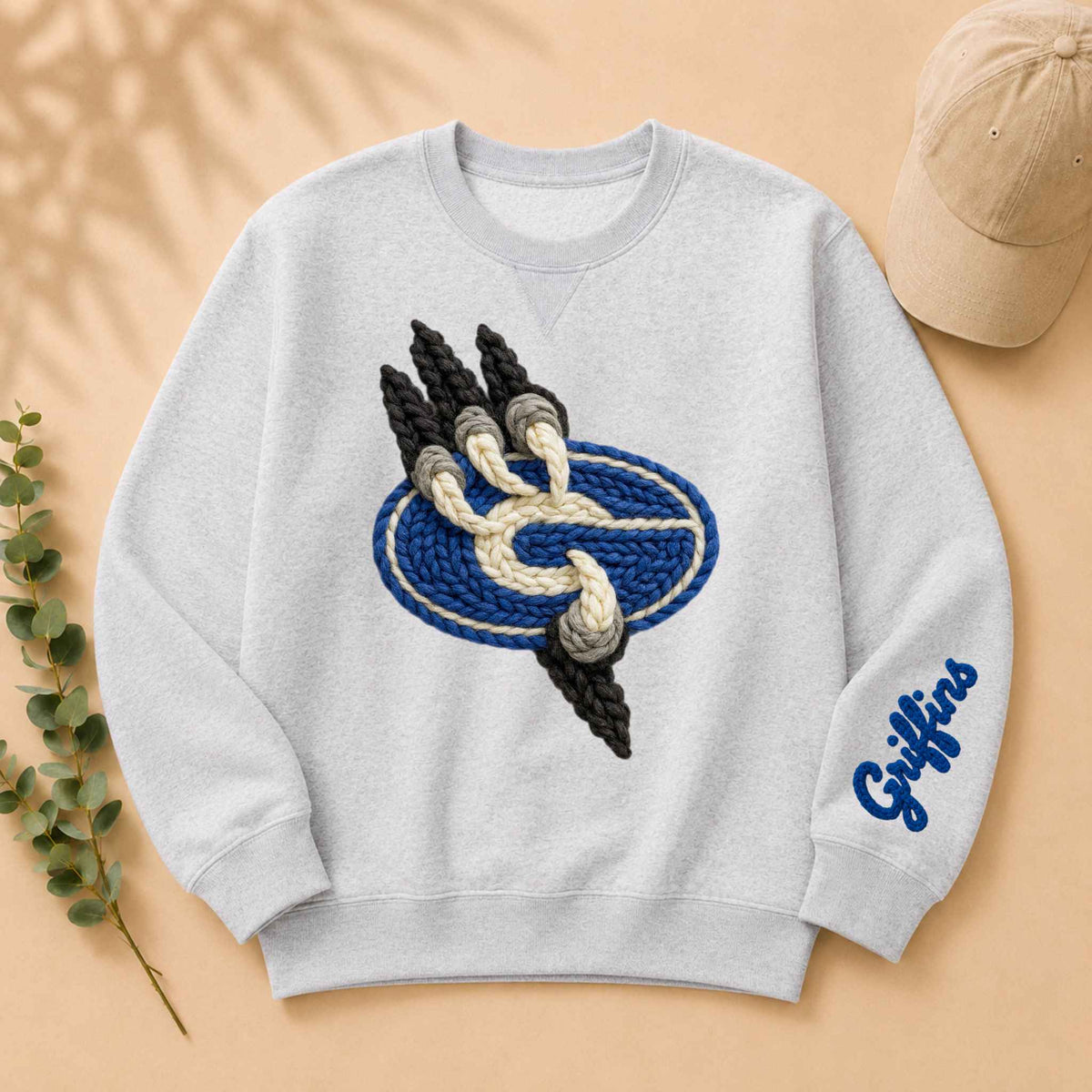 Light gray sweatshirt with braided griffin emblem in blue and white, black accents