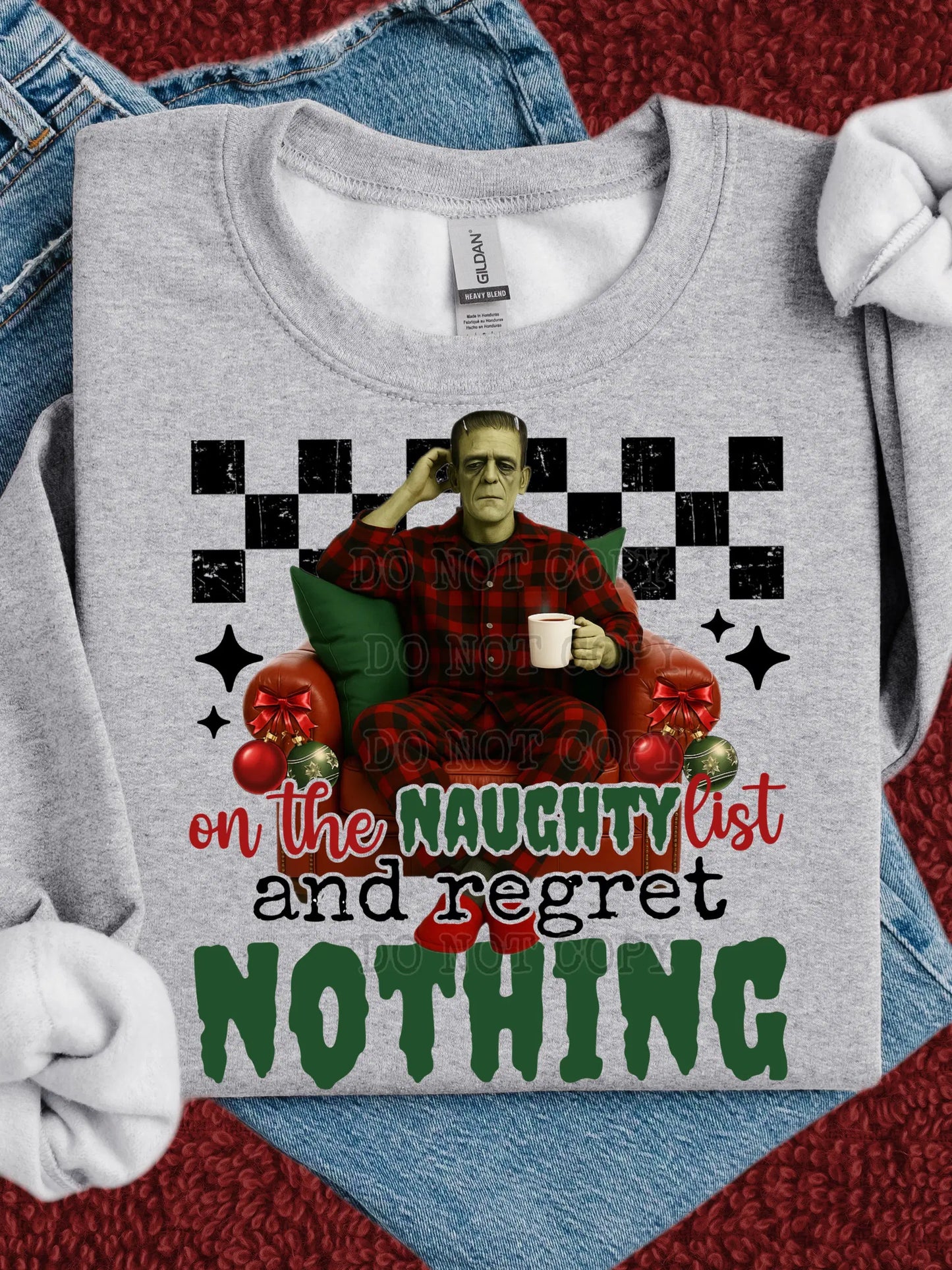 Funny Frankenstein Christmas Sweatshirt: 'On the Naughty List and Regret Nothing'. Holiday crewneck with monster in armchair.