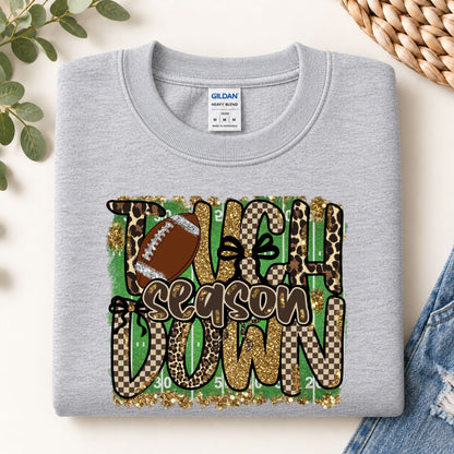 Light gray football sweatshirt with “Touchdown Season” leopard camo graphic, crew neck.