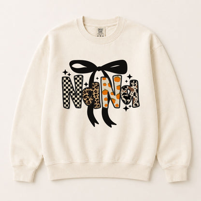 Cream crewneck sweatshirt with large black bow and fall letter graphic in checkered and leopard.