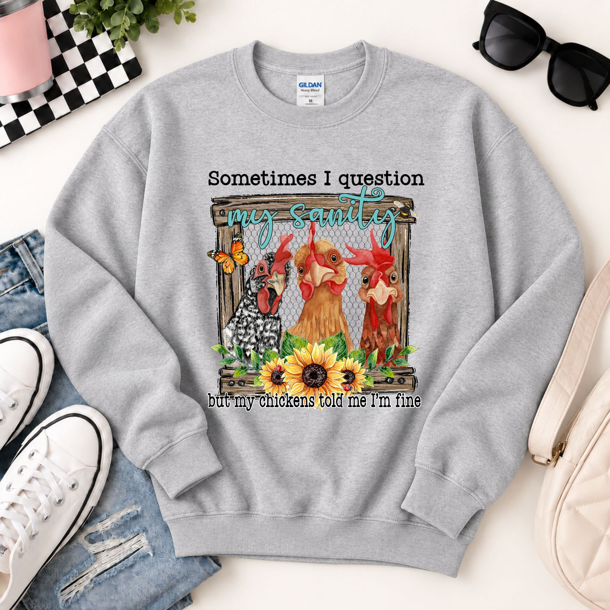 Grey crewneck sweatshirt with centered chicken graphic print and quote text.