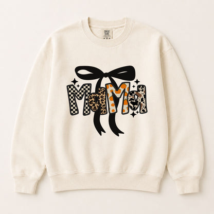 Cream crewneck sweatshirt with black bow and fall letter graphic in checkered and leopard prints.