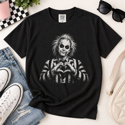 Black graphic T-shirt laid flat with heart-hands spooky character print