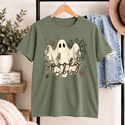 Green short-sleeve Halloween graphic tee with white ghost face, spider web, and “spooky vibes”