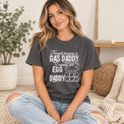 Dark gray graphic tee worn by model; white GAS DADDY egg slogan print