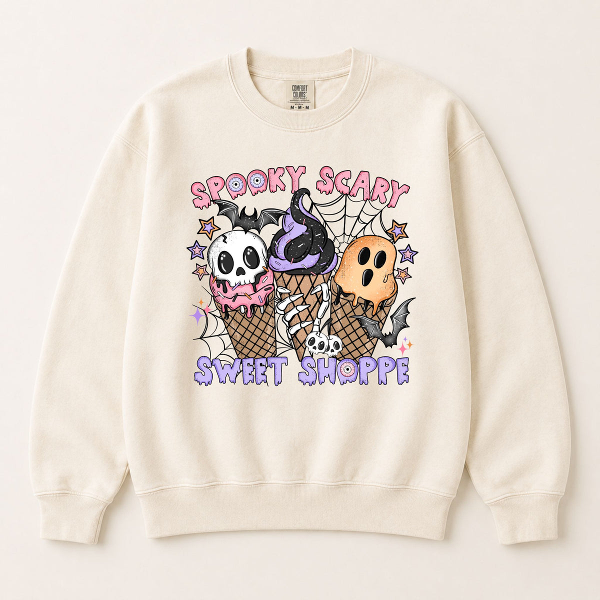 Cream pullover sweatshirt with centered Halloween graphic of skulls and ice-cream cones