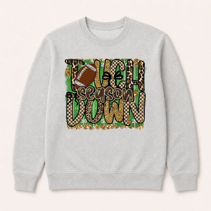 Light gray crewneck sweatshirt with centered “Touchdown Season” leopard camo football print.
