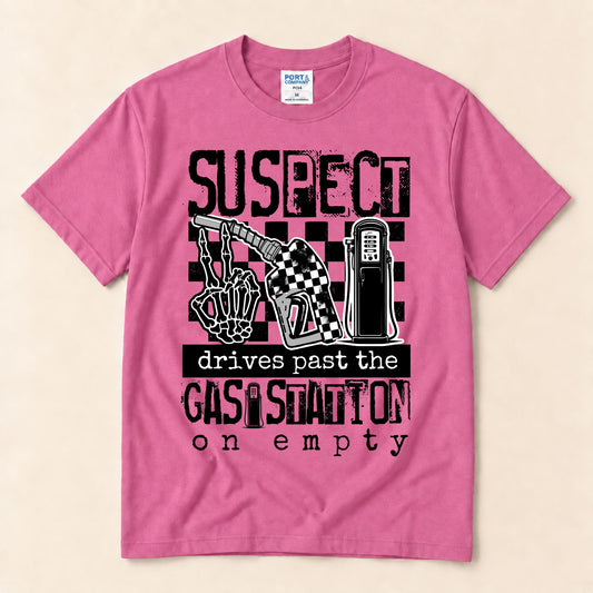 Pink graphic tee with front black suspect gas station on empty typography