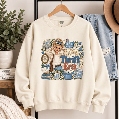 Cream graphic crewneck sweatshirt on hanger, front 'In My Thrift Era' artwork