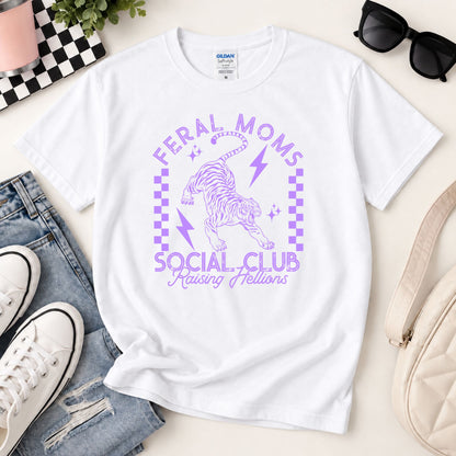 White graphic tee with purple “Feral Moms Social Club” unicorn lightning artwork