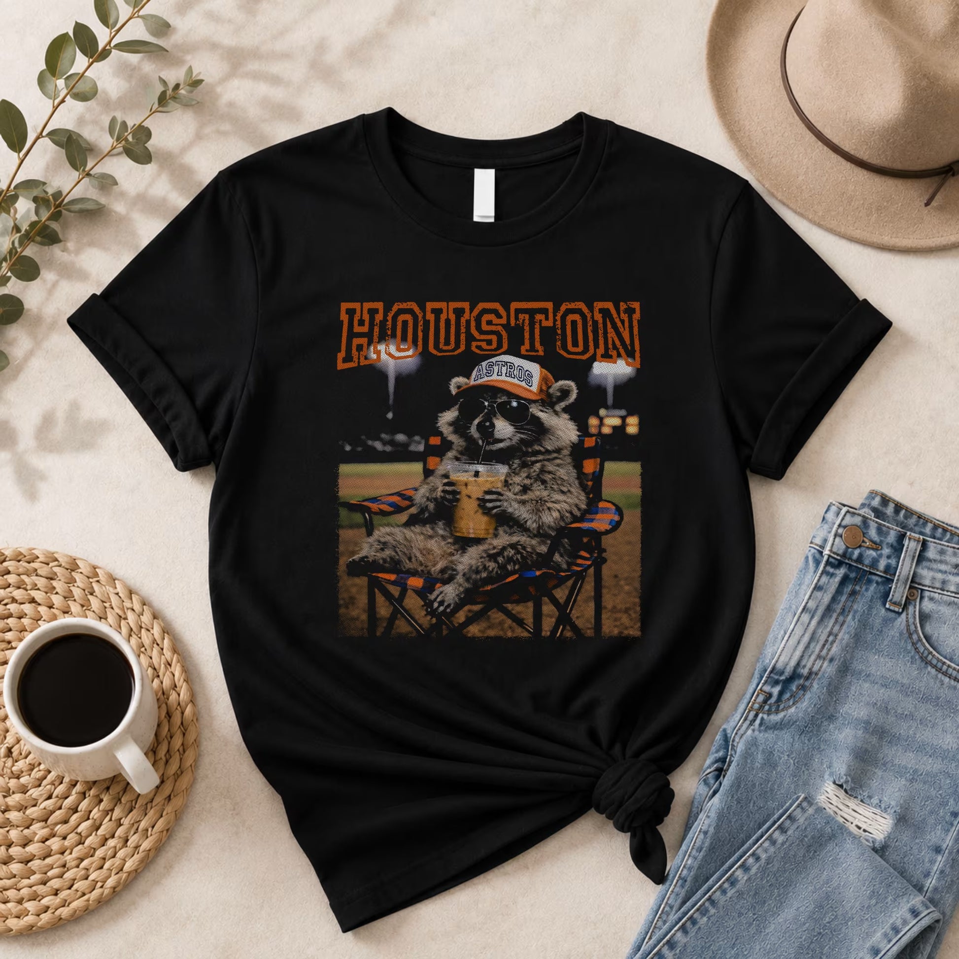 The Vintage Houston Raccoon Baseball Tee by Becca's Banging Designs LLC is an oversized black graphic shirt with a raccoon in sunglasses and an Astros cap—perfect for game day, styled casually with jeans and your favorite accessories.