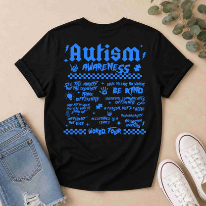 Black t-shirt with Blue 'Autism World Tour' design on a light surface with casual items.