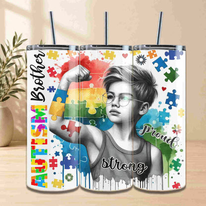 Tumbler with a design of a person flexing their arm with colorful puzzle pieces and text on a wooden surface.