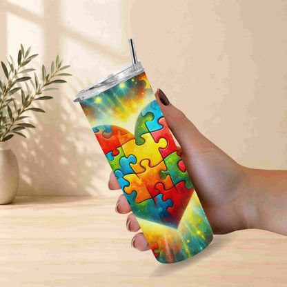 Colorful puzzle-patterned tumbler held by a hand with a light background