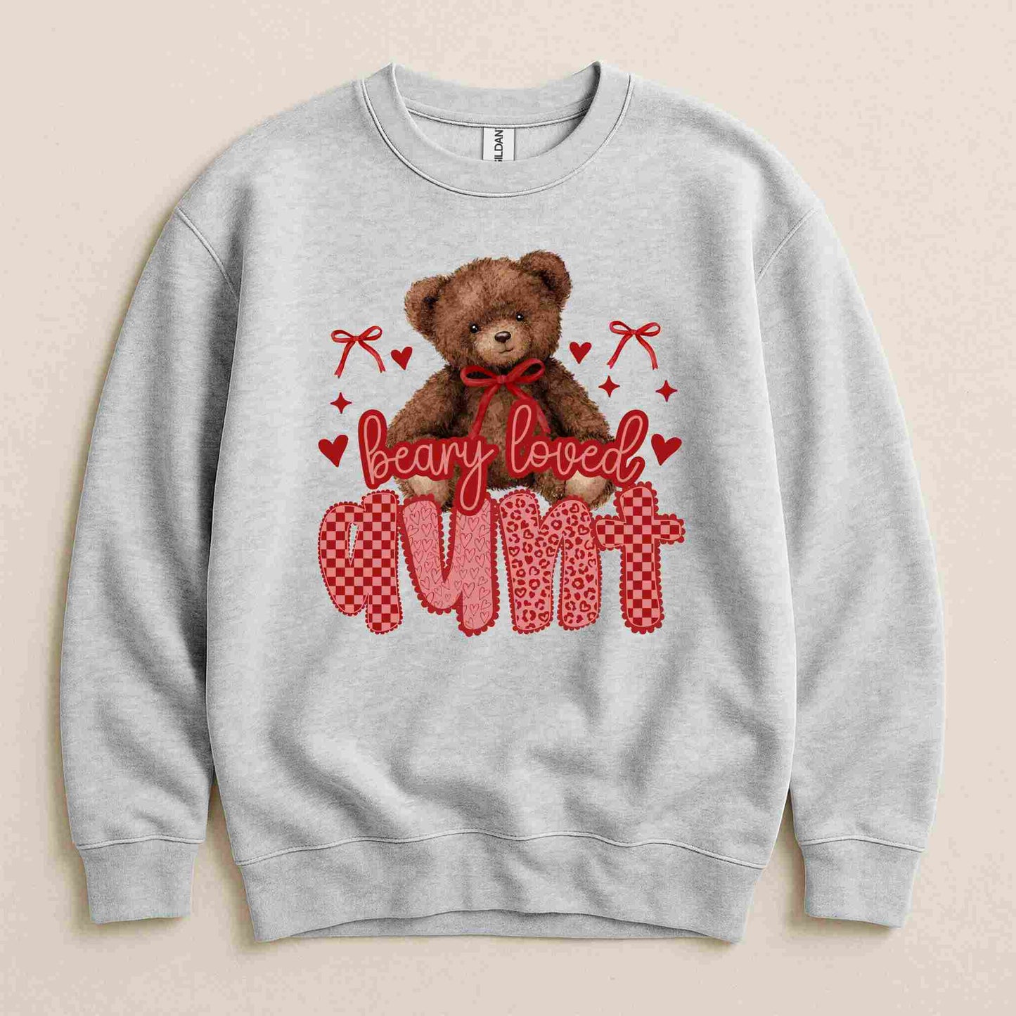 Gray sweatshirt with teddy bear graphic and text 'Beary Loved Aunt' on a beige background