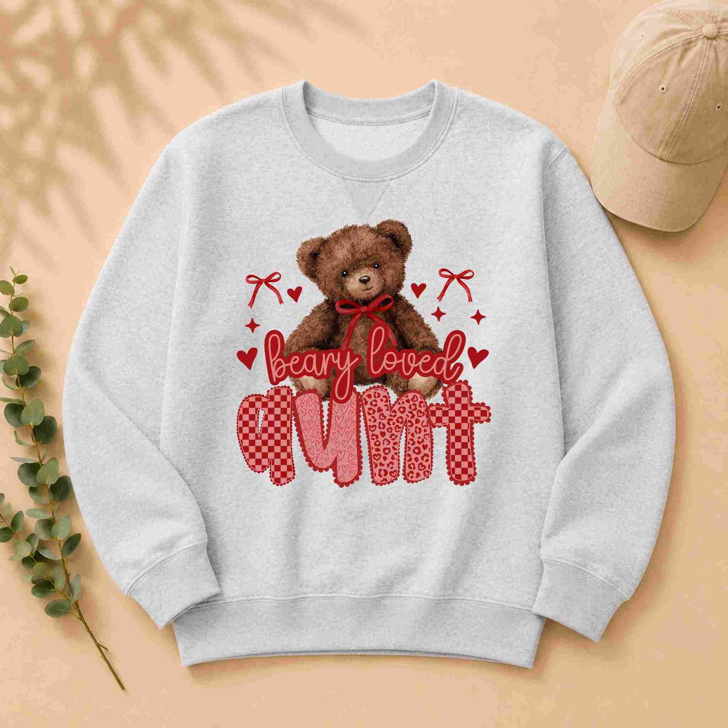 Gray sweatshirt with teddy bear graphic and 'Beary Loved Mum' text on a beige background