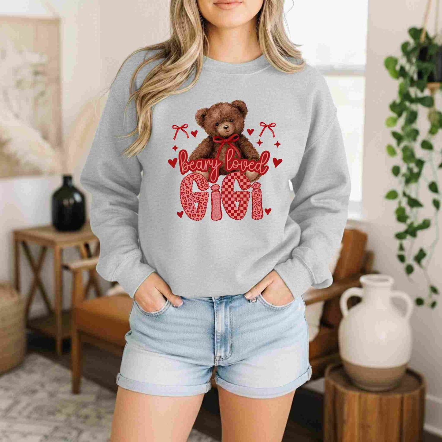 Person wearing a gray sweatshirt with a teddy bear graphic and text in a home setting