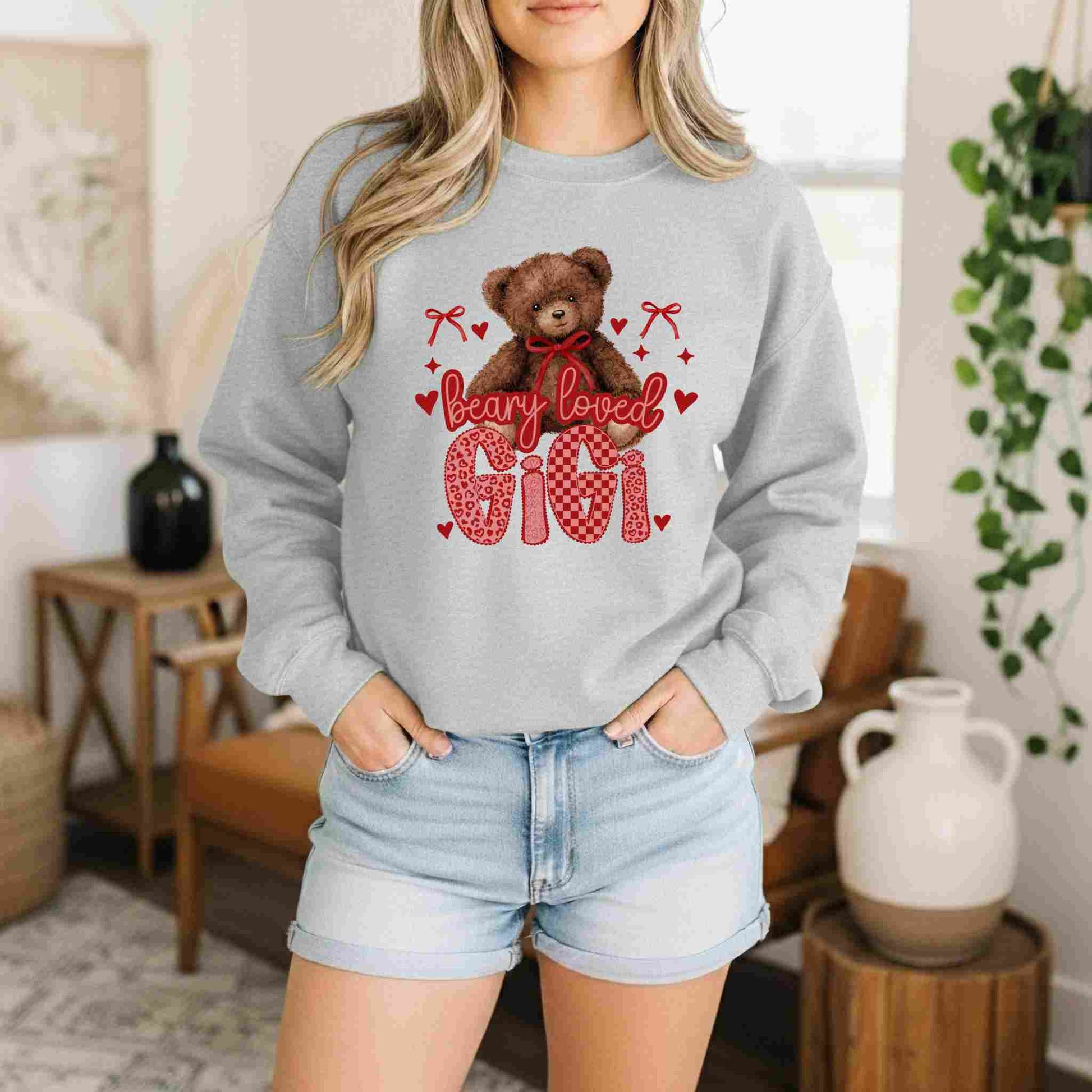 Person wearing a gray sweatshirt with a teddy bear graphic and text in a home setting