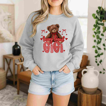 Person wearing a gray sweatshirt with a teddy bear graphic and text in a home setting