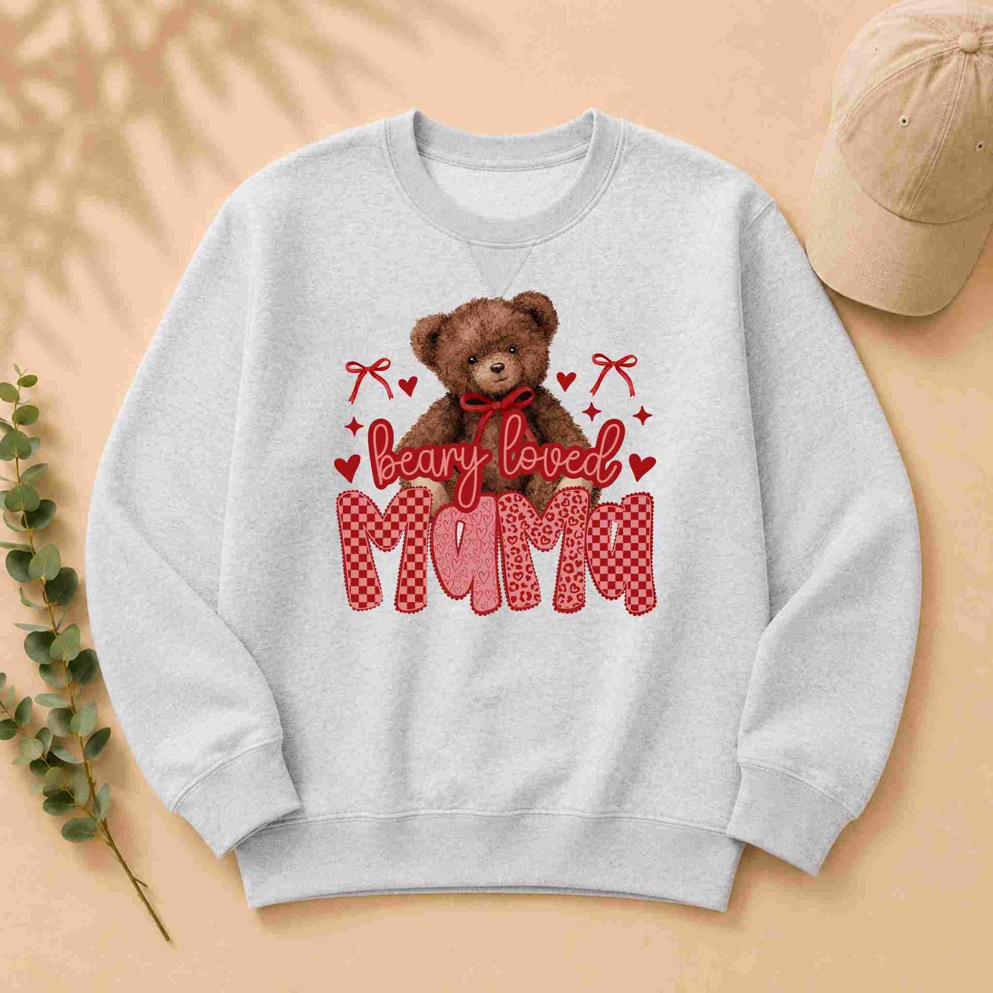 Gray sweatshirt with a teddy bear graphic and 'bearly loved mama' text on a beige background.