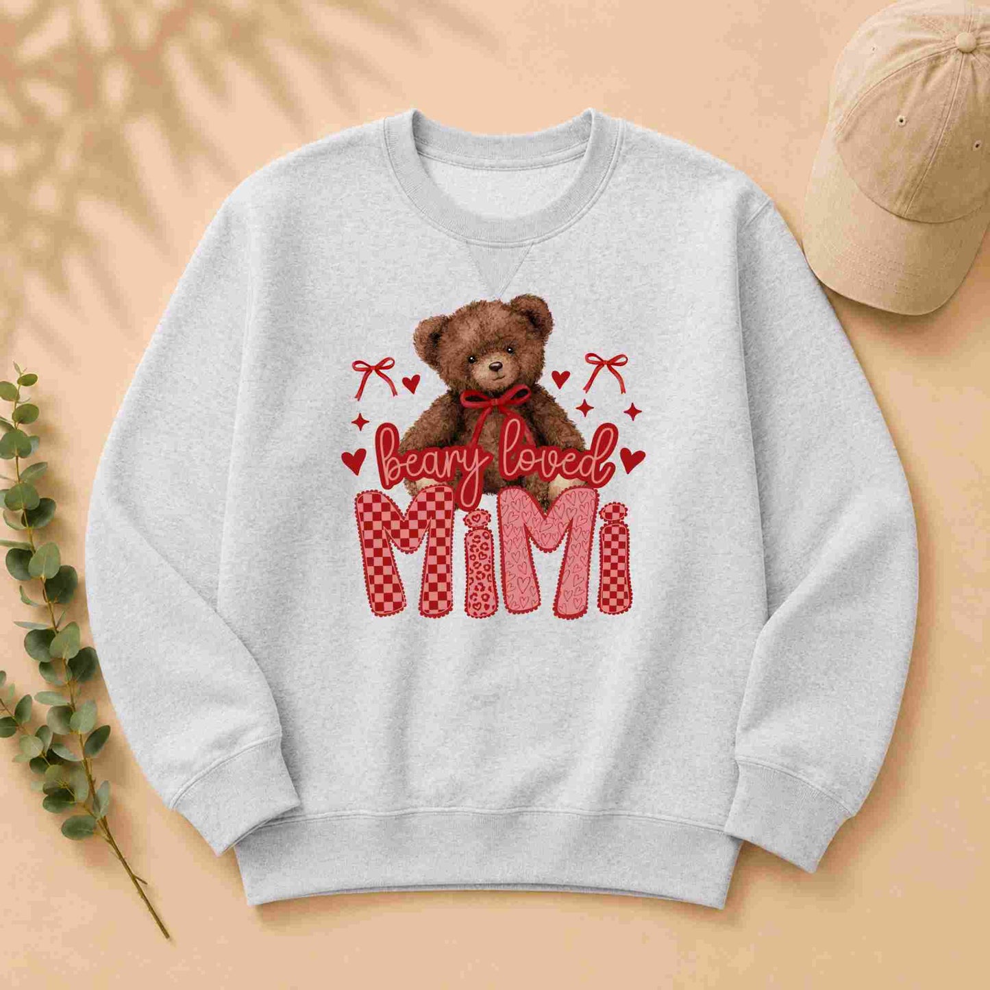 Gray sweatshirt with teddy bear graphic and 'Beary Loved Mimi' text on a beige background