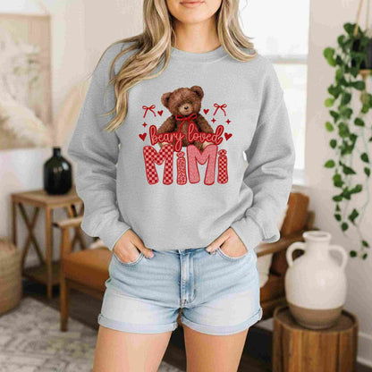 Person wearing a gray sweatshirt with a teddy bear graphic and 'bearly loved cum' text in a home setting.