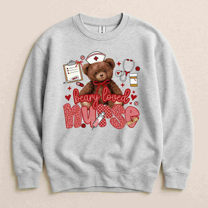 Becca's Banging Designs' Beary Loved Nurse Sweatshirt features a cute teddy bear in a nurse hat, surrounded by medical items and hearts—“Beary loved nurse” appears in red and pink. A cozy, thoughtful gift for nurses!.