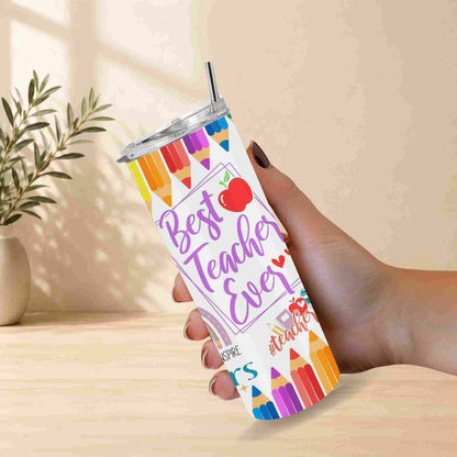 A hand holds the "Best Teacher Ever | 20oz Tumbler," decorated with pencils and a red apple. Against a neutral wall and a small potted plant, this vibrant drinkware makes an ideal teacher gift.