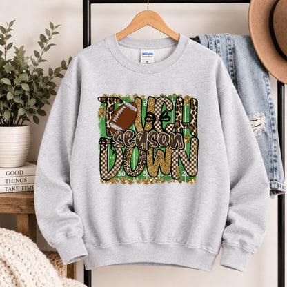 Light gray crewneck sweatshirt on hanger with “Touchdown Season” leopard camo football design.
