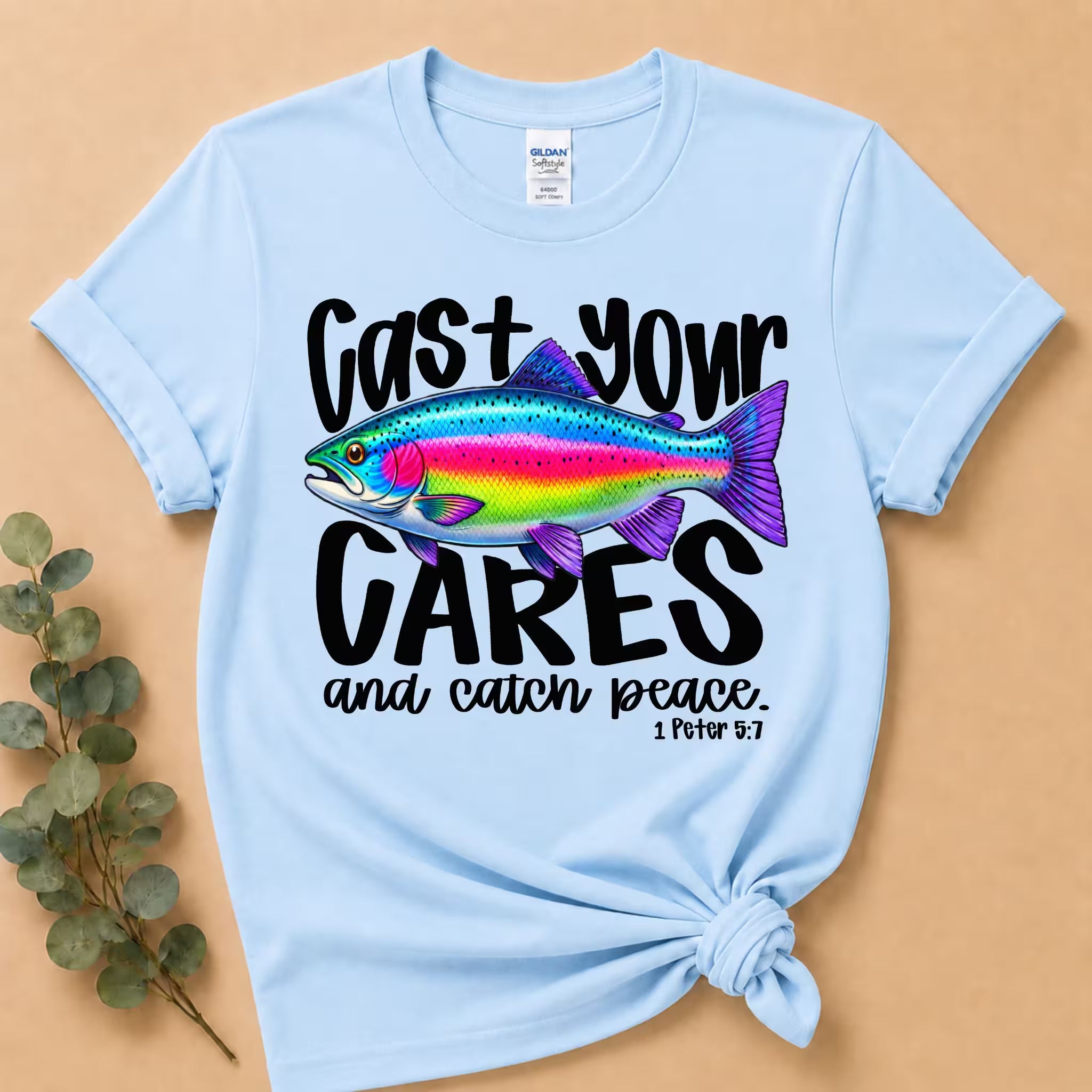 Light blue t-shirt with colorful fish graphic and text on a beige background