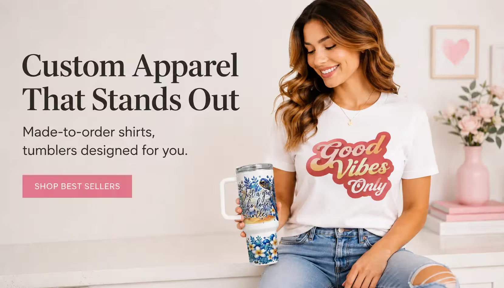 Modern ecommerce hero banner featuring a smiling woman wearing a “Good Vibes Only” graphic t-shirt and holding a custom floral tumbler in a bright boutique-style setting with promotional text for made-to-order custom apparel and tumblers.