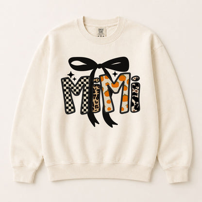 Cream crewneck sweatshirt with black bow and fall “Mimi” letter graphic in leopard and orange.