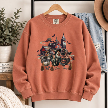 Rust-orange crewneck sweatshirt with witchy chicken and haunted house front design