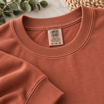Rust-orange sweatshirt neckline and sleeve seam with Comfort Colors neck label
