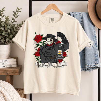 Cream graphic tee hanging on wooden hanger, plague doctor and red roses front print