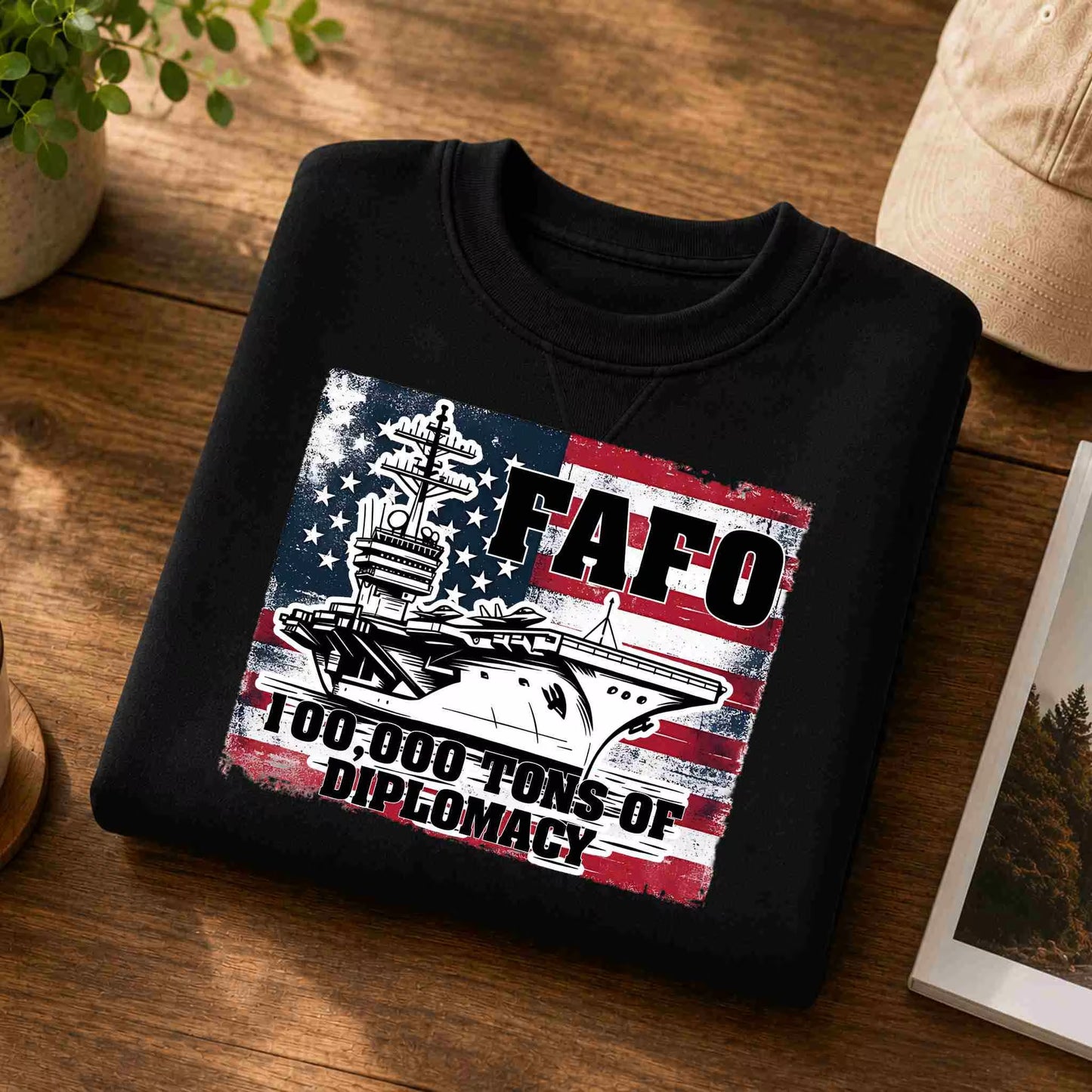 Black sweatshirt with graphic design and text on a wooden surface