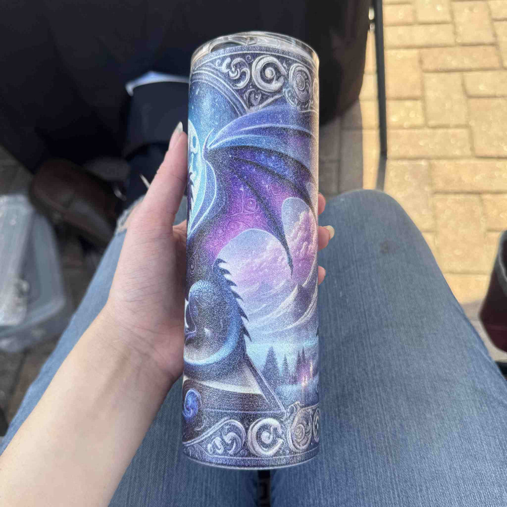 Tumbler with dragon design held by a person outdoors