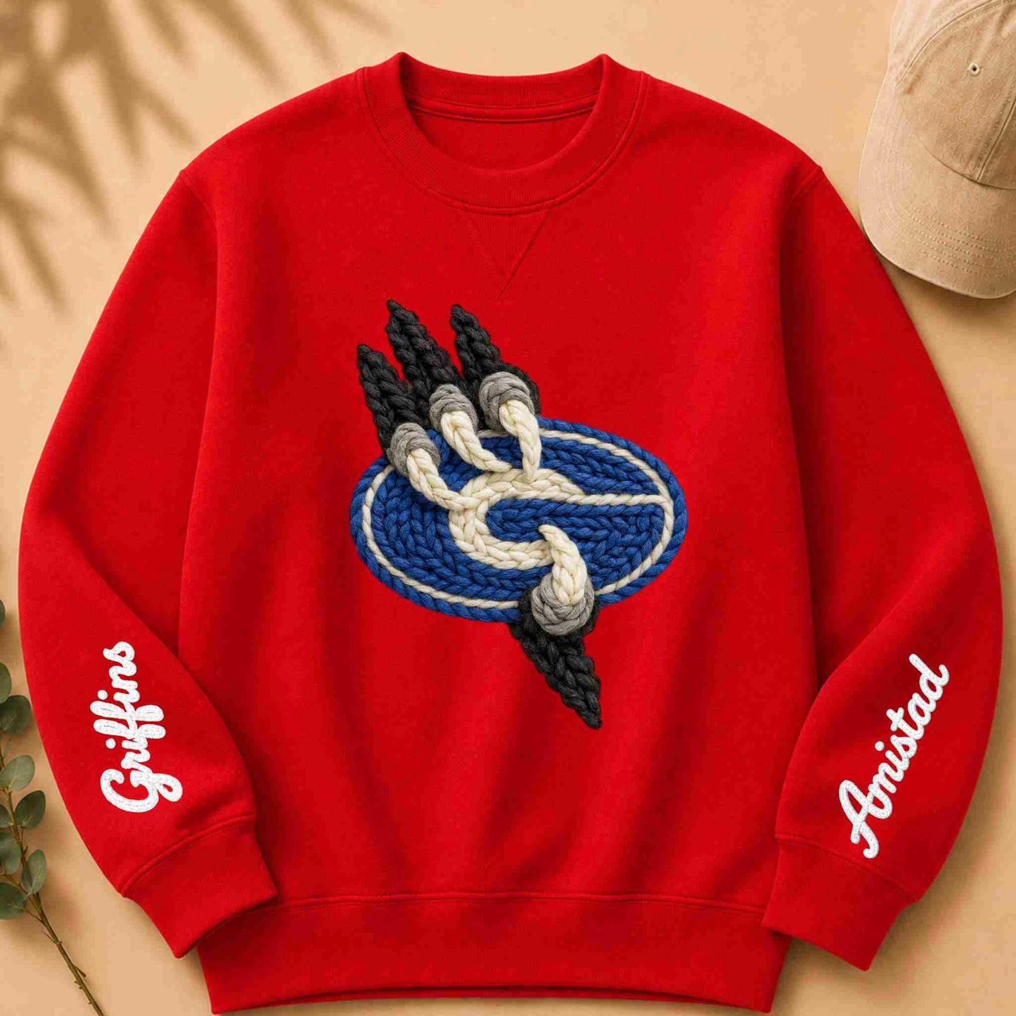 Red sweatshirt with a logo and text on sleeves against a beige background