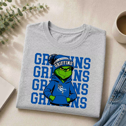 The Griffins Graphic Tee Youth Comfort and School Spirit by Becca's Banging Designs features a gray tee with a cartoon Grinch in a blue Griffins hoodie, “GRIFFINS” text background—perfect for school pride.
