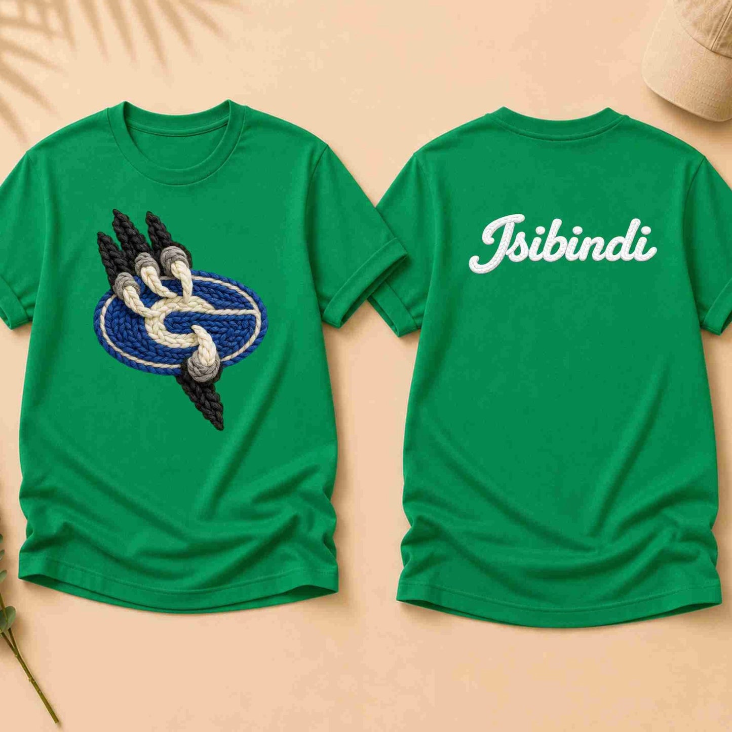 Green t-shirt with a design on the front and 'Isibindi' text on the back, displayed on a beige surface.