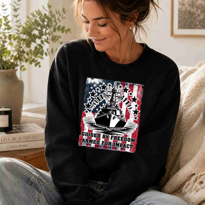 Woman wearing a black sweatshirt with a graphic design sitting on a couch.