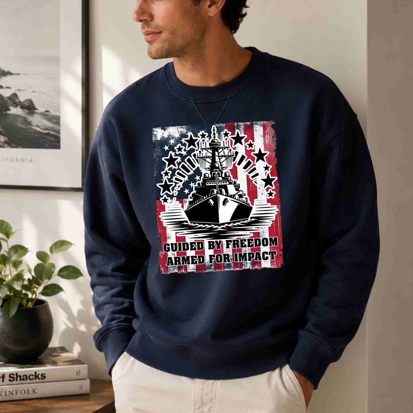 Man wearing a navy blue sweatshirt with a graphic design, standing indoors.