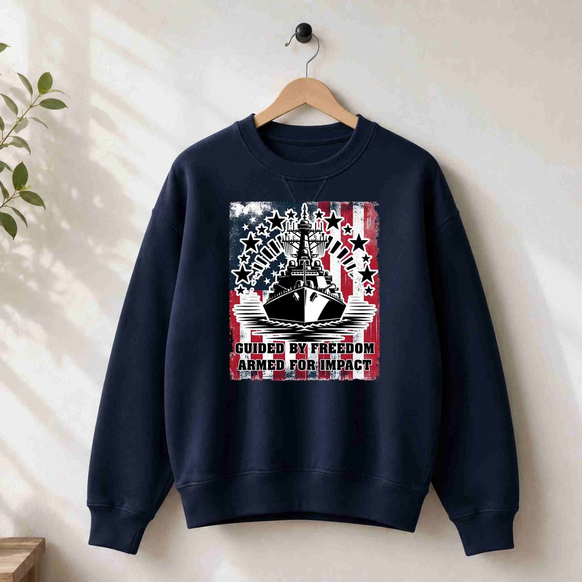 Navy blue sweatshirt with a graphic design on a hanger against a white wall.