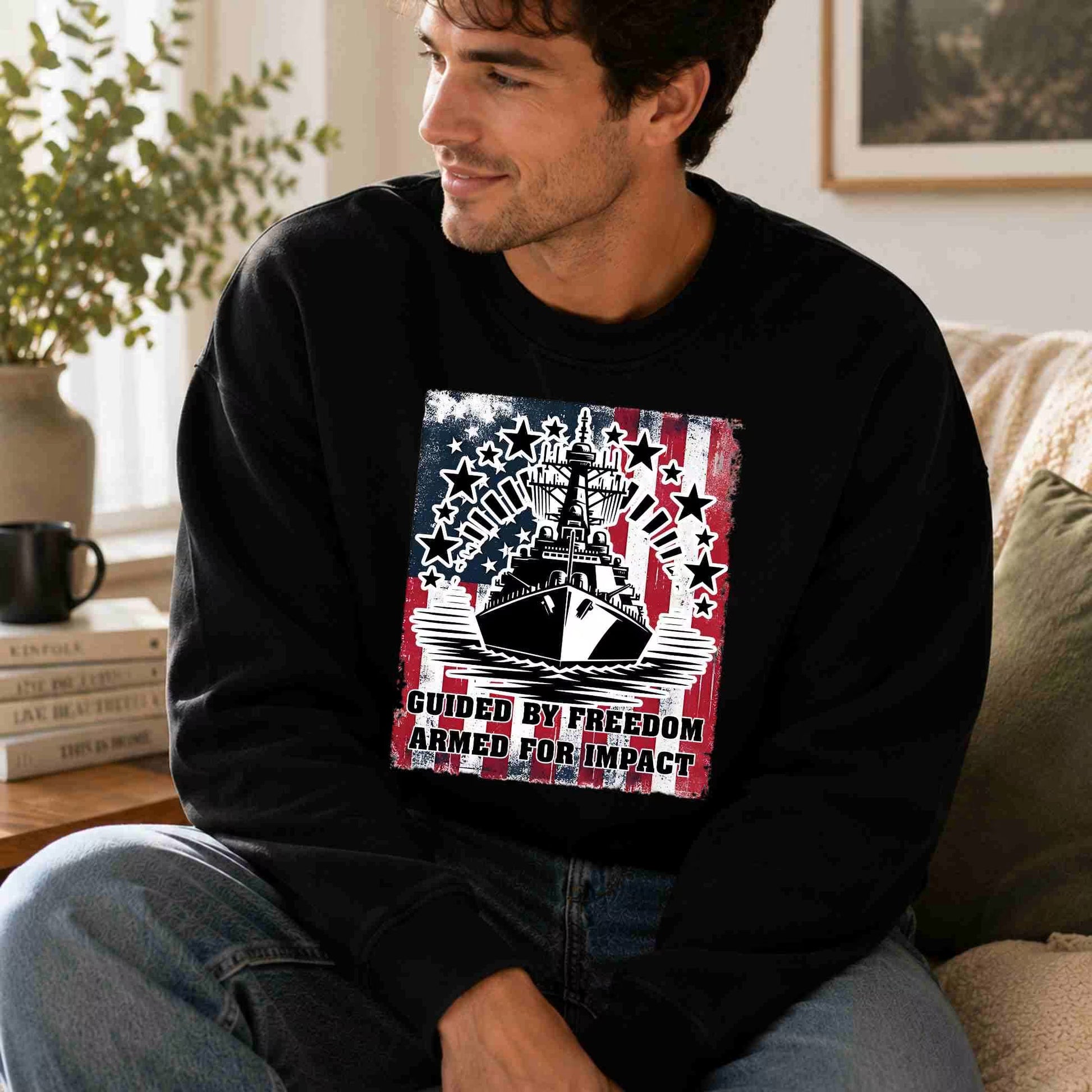 Man wearing a black sweatshirt with a graphic design sitting on a couch.