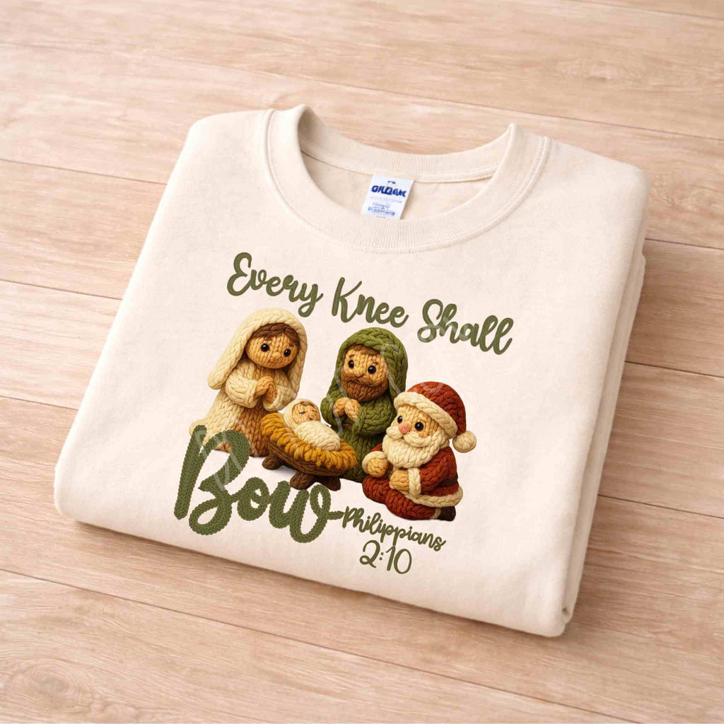 Every Knee Shall Bow Christmas Sweatshirt featuring a nativity scene design with the text and scripture Philippians 2:10.
