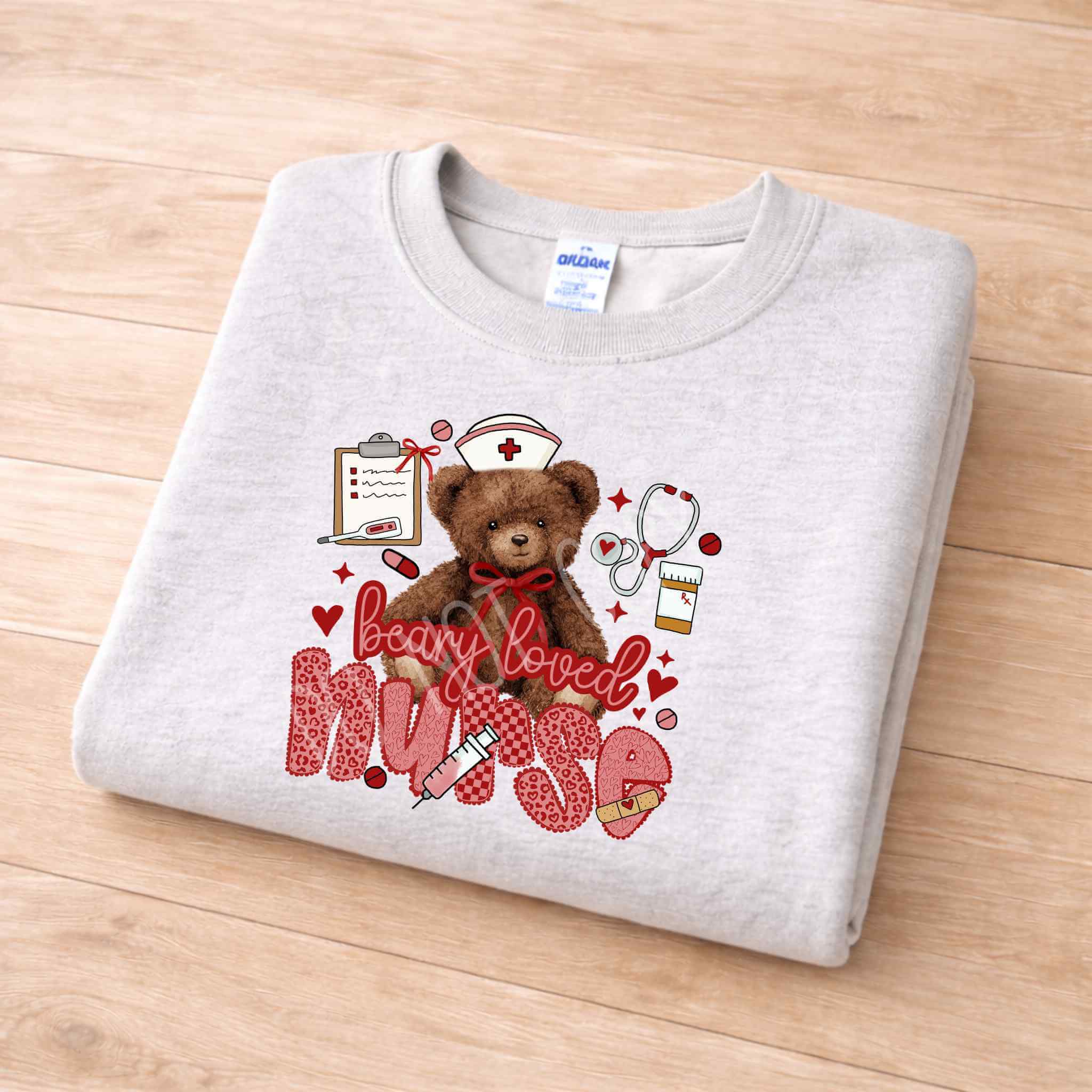Beary Loved Nurse Sweatshirt Comfort Style and Care featuring an adorable teddy bear and nurse-themed icons.