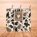 Cowgirl Tumbler - Cowgirls Don’t Cry 20oz with cow print design on wooden background.