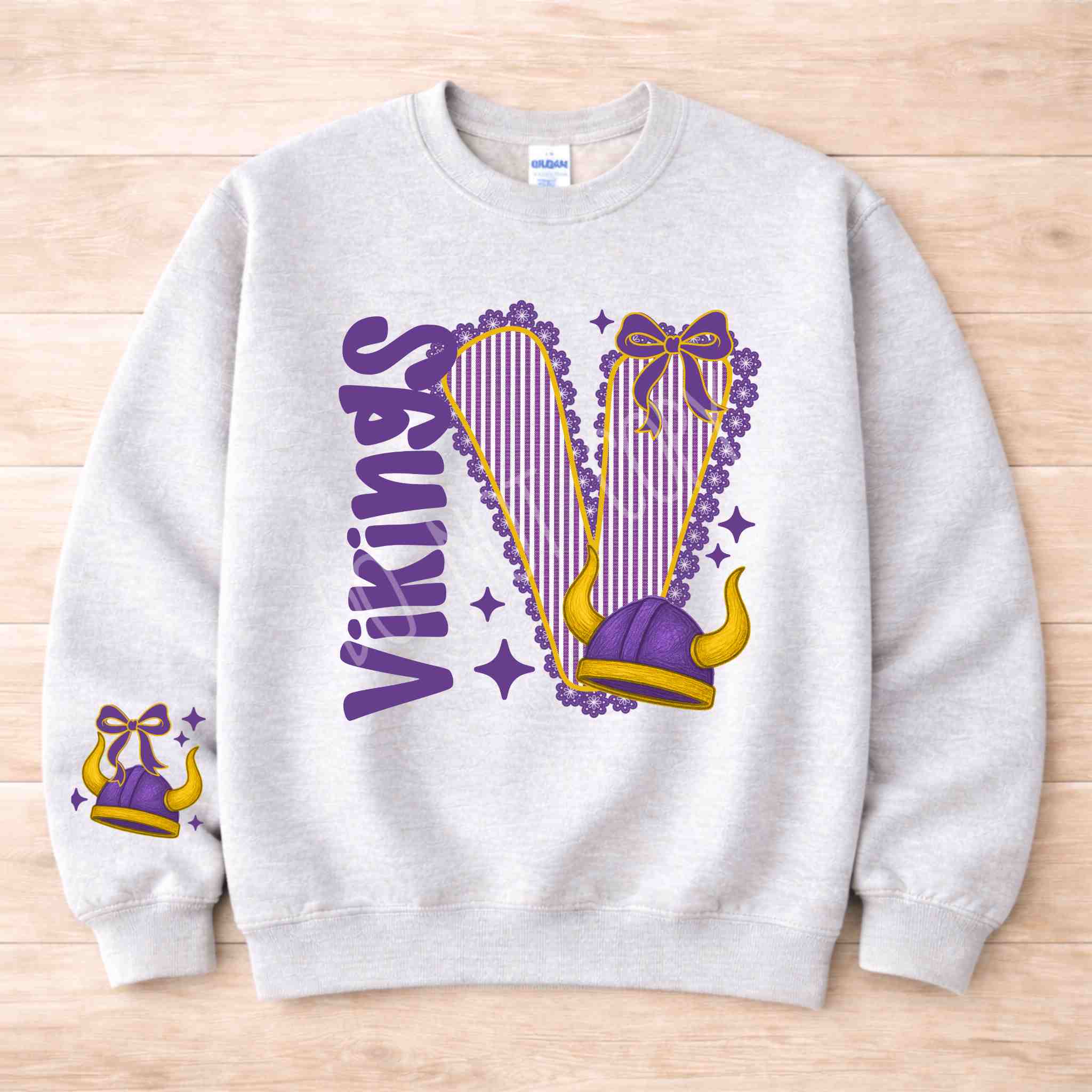 Vikings School Spirit Sweatshirt featuring varsity letter and bow accents in purple and gray.