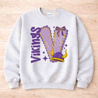 Vikings School Spirit Sweatshirt featuring bold varsity letters and a purple bow design.